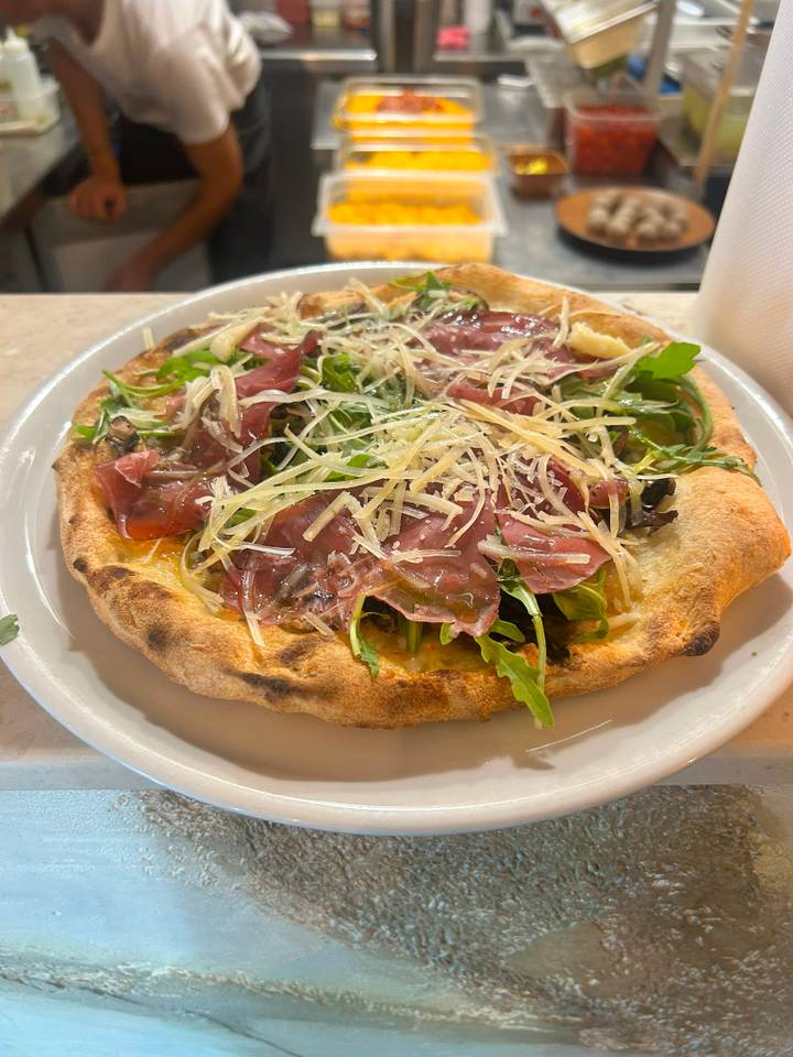 Pizza Bresaolina su piatto bianco, sul banco di marmo