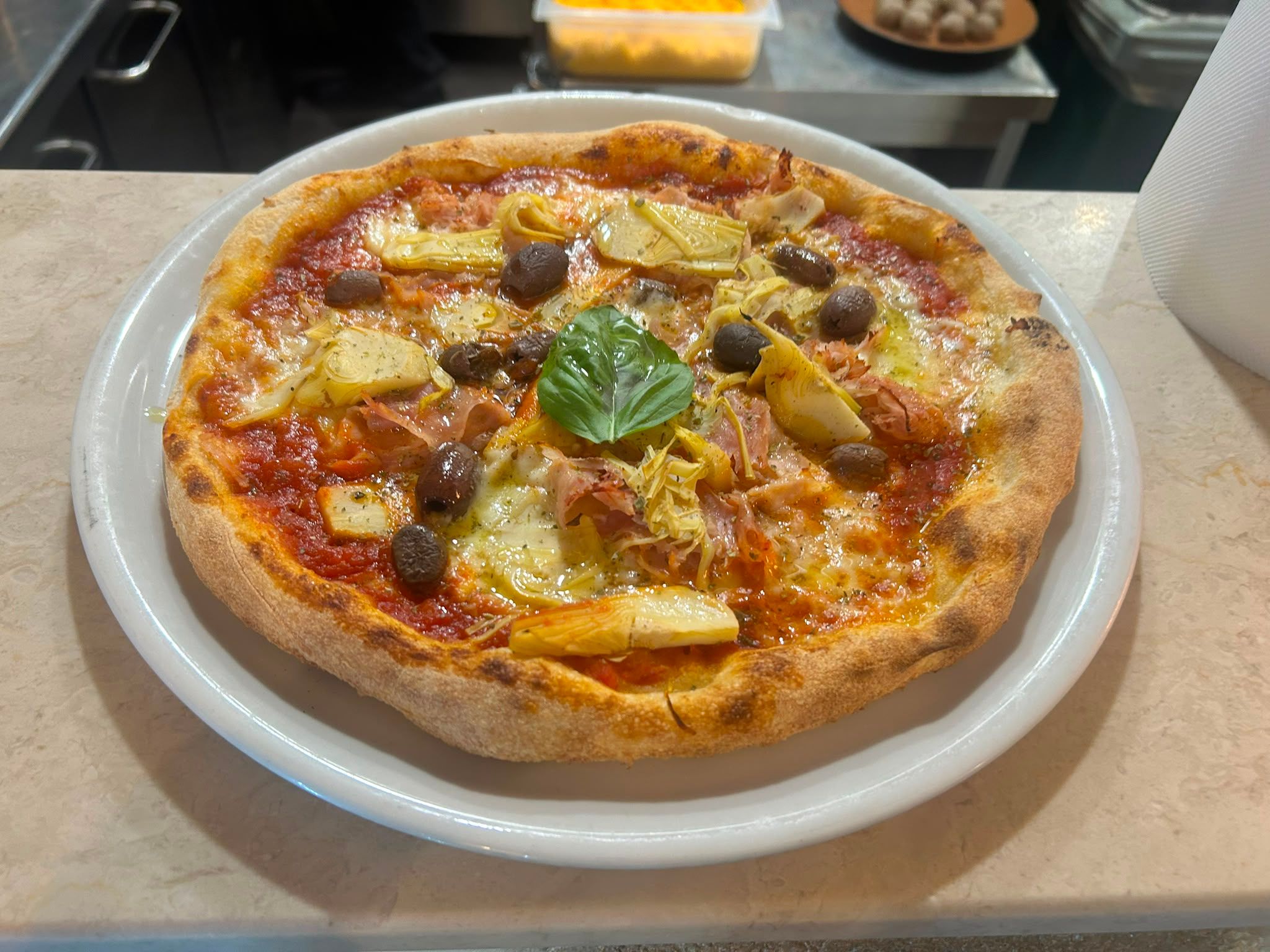 Pizza 4 Gusti su piatto bianco, sul banco di marmo